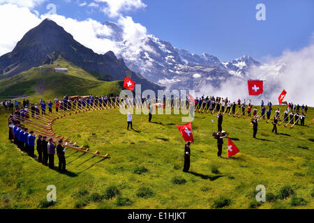 Les soufflantes de cor des Alpes et lanceurs de drapeaux, grosses Alphorntreffen festival, sur la montagne Männlichen, Kleine Scheidegg col Banque D'Images