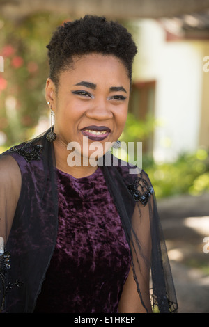 Outdoor portrait d'une jeune femme noire dans une robe de velours violet Banque D'Images