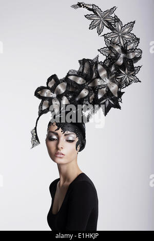 La fantaisie. Le surréalisme. Femme exceptionnelle dans le quartier branché de chapeaux avec des fleurs Banque D'Images