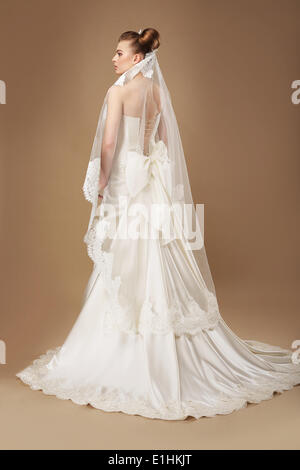 Femme gracieuse robe somptueuse à la lumière et voile Banque D'Images