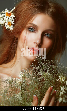 Pure beauté. Auburn Girl holding Bouquet de fleurs sauvages. La tendresse Banque D'Images