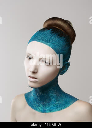 L'expression. La fantaisie. Femme excentrique peinte en bleu avec la peau et les cheveux. La coloration Banque D'Images