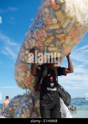 RIO DE JANEIRO, Brésil - le 25 janvier 2014 : l'homme brésilien possède une collection de poubelles pour le recyclage sur la plage d'Ipanema. Banque D'Images