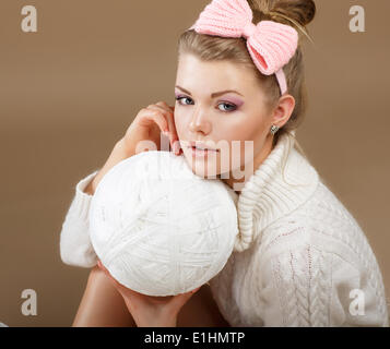 Pure beauté. Femme en blanc en tricot moelleux chandail avec Hank de thread Banque D'Images