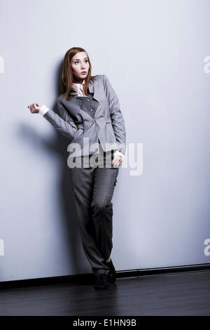 Le modèle de mode. Jeunes et belles dans womqn posant en costume gris studio Banque D'Images