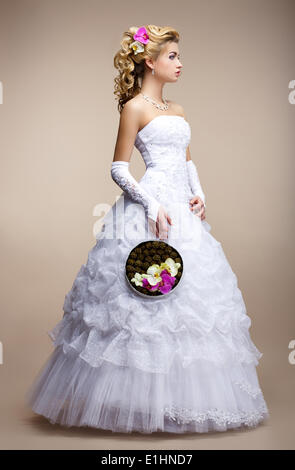 Style de mariage. Bride wearing White Dress et des gants. Bouquet de fleurs à la mode Banque D'Images