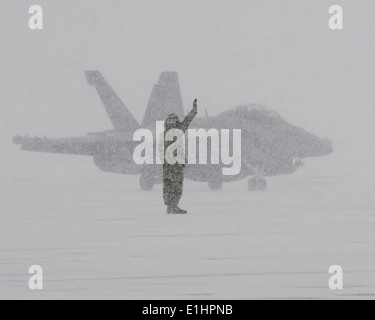 Un marin américain affecté à l'Escadron d'attaque électronique (VAQ) 132 signaux pour le pilote d'un F/A-18G Growler avion pendant qu'il les taxis Banque D'Images