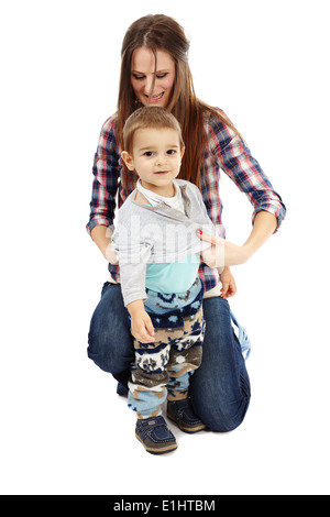 Young caucasian mother s'habillant avec son petit garçon, isolé sur fond blanc Banque D'Images