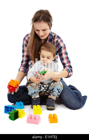 Mère et son fils jouer avec des cubes colorés, sitting on floor Banque D'Images