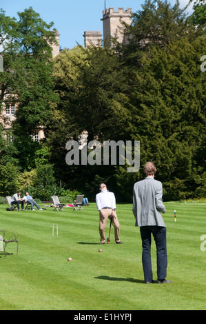 Les élèves jouer au croquet sur la pelouse du jardin de Trinity College, Oxford. Banque D'Images