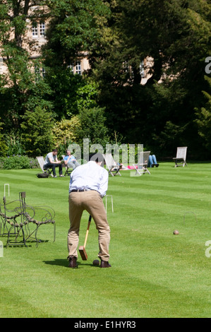 Les élèves jouer au croquet sur la pelouse du jardin de Trinity College, Oxford. Banque D'Images