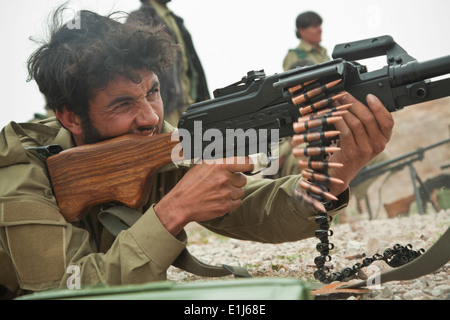 Un agent de la police locale afghane de forêt une mitrailleuse au cours de l'entraînement au tir réel effectué par les agents de la Police nationale afghane dans il Banque D'Images