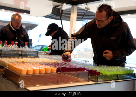 Les barmans sur shot stall pouring l'alcool dans des verres, Carnaval d'Ostende, Belgique Banque D'Images