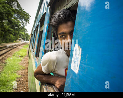 5 juin 2014 - Yangon, Yangon, Myanmar Région : un passager sur le Train Circulaire de Yangon regarde par la fenêtre. La circulaire est train de Yangon un train de banlieue que les cercles Yangon, Myanmar (Birmanie), Rangoon. La piste est de 45 kilomètres de long, fait 38 s'arrête et prend environ trois heures pour faire une boucle de la ville. (Crédit Image : © Jack Kurtz/ZUMAPRESS.com) Banque D'Images