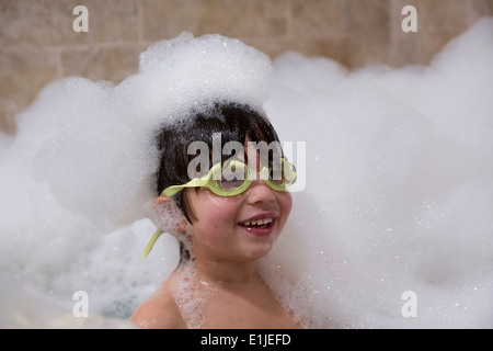 Portrait de jeune garçon portant ces lunettes in bubble bath