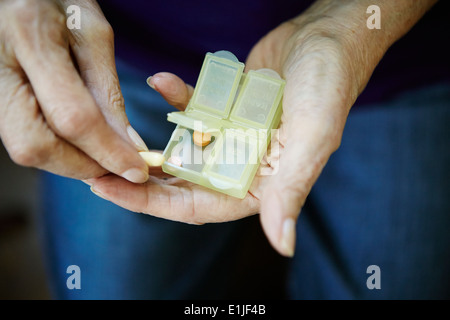 Près de 82 ans, senior woman's hand with pill box Banque D'Images