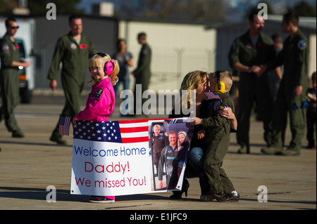 Stacey Savage, agenouillée, épouse de l'US Air Force, le Lieutenant-colonel Pierre Dukan un F-16 Fighting Falcon pilote avion et directeur de l'op Banque D'Images