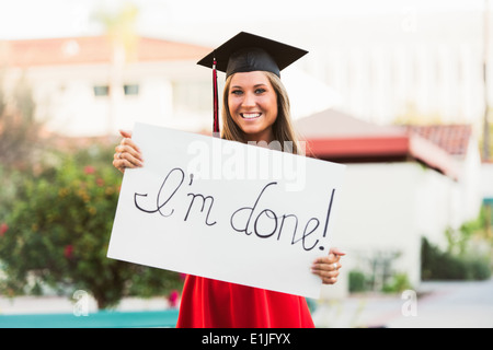 Female graduate holding placard Banque D'Images