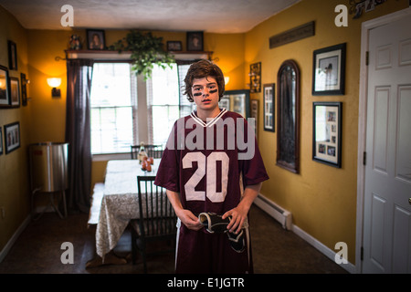 Teenage boy wearing lacrosse uniforme, debout dans la salle à manger Banque D'Images