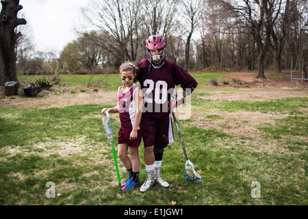 Brother and sister wearing lacrosse uniforms Banque D'Images