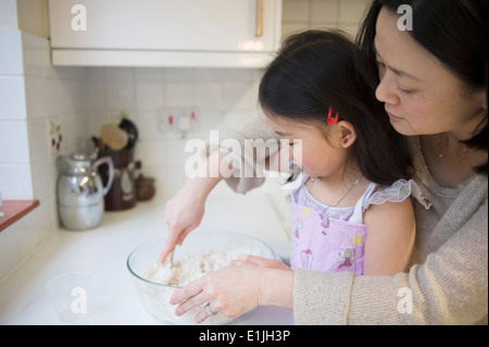 Mère et fille en cuisine, le mélange des ingrédients dans un bol Banque D'Images