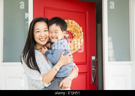 Portrait of mid adult woman and young son on porch Banque D'Images