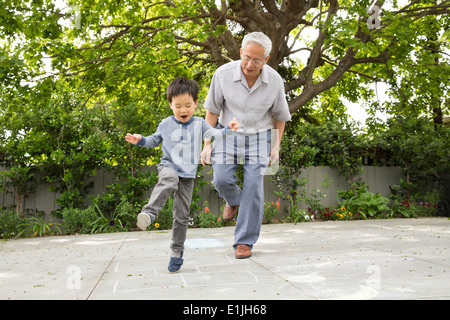 Grand-père jouant à la marelle avec petit-fils Banque D'Images