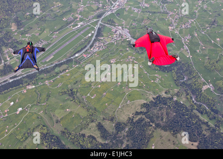 Deux hommes volant au-dessus des champs en wingsuit Banque D'Images