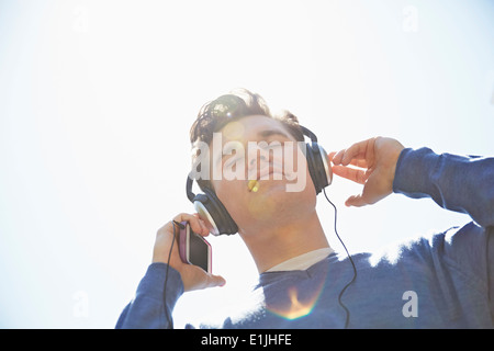 Young man wearing headphones listening to music Banque D'Images