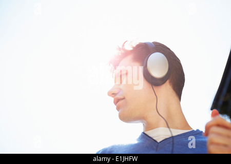 Young man wearing headphones listening to music Banque D'Images