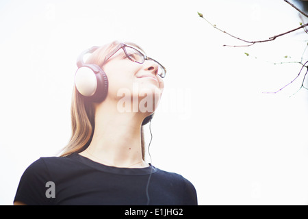 Young woman wearing headphones listening to music Banque D'Images
