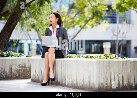 Femelle jeune businessman standing outside office Banque D'Images