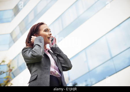 Jeune femme businesswoman talking on smartphone outside office Banque D'Images