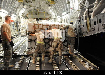 Les aviateurs américains avec le 386e Escadron de préparation logistique expéditionnaire palettes Charge de l'aide humanitaire sur un C-17 Banque D'Images