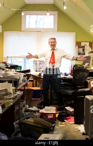 Businessman in Hoarders' Messy Home Office, USA Banque D'Images