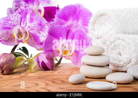 L'établissement Spa avec des pierres, lilas orchidées et des serviettes est isolé sur fond blanc Banque D'Images