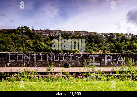 Pro IRA de la continuité de l'écriture graffiti peint sur un mur le long de la rivière Foyle, Derry, Londonderry, Irlande du Nord, Royaume-Uni, Europe Banque D'Images