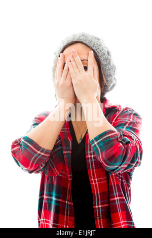 Jeune femme peeking through hands covering face Banque D'Images