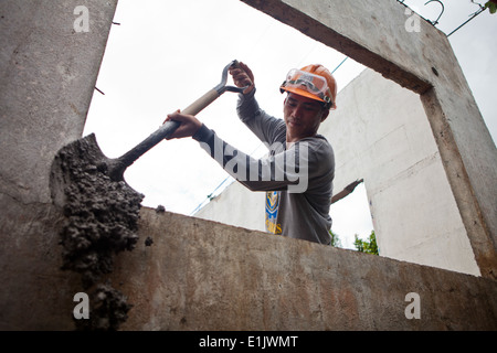 La marine philippine Maître de 2e classe Lito Albuera, ingénieur à Naval Forces Southern Luzon, verse dans une école du ciment Banque D'Images