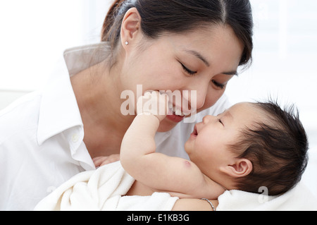 Parution modèle Mother smiling and holding baby girl. Banque D'Images