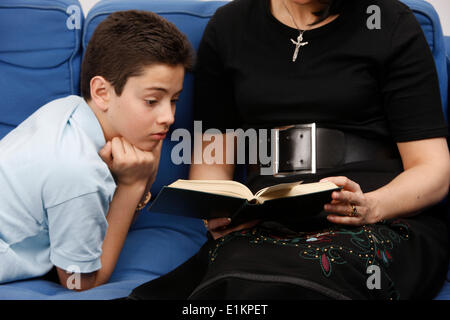 Boy reading Bible avec sa mère Banque D'Images