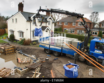 L bâtiment maison, la livraison de matériaux de construction a été levé à partir de son camion du marchand Banque D'Images