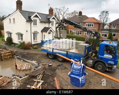 L bâtiment maison, la livraison de matériaux de construction a été levé à partir de son camion du marchand Banque D'Images