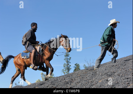 Un touriste à cheval est conduit jusqu'à la lave noire de la pentes du volcan Pacaya, active de Cono Mackenney. Guatemala Banque D'Images