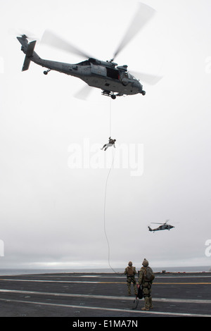 Les marins américains avec des explosifs et des munitions de l'unité mobile d'un rappel 3 MH-60S hélicoptère hélicoptère Seahawk affectés à la mer Banque D'Images