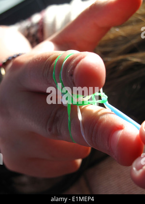 Young Girl making rainbow loom bracelet sur ses doigts Banque D'Images