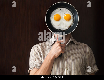 Portrait jeune homme noir derrière poêle avec oeufs brouillés Banque D'Images