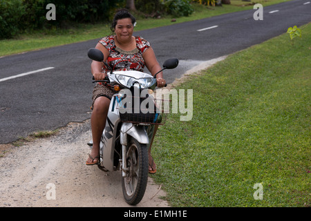 L'île de Rarotonga. L'île de Cook. Polynésie française. Océan Pacifique Sud. Deux personnes obèses conduire une motocyclette sur une route sur l'île Banque D'Images