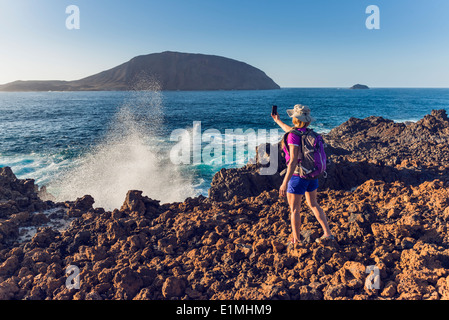 Femme prise d'une photo à l'île de La Graciosa, Lanzarote, îles Canaries, Espagne. Banque D'Images