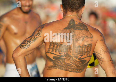 RIO DE JANEIRO, Brésil, le 18 janvier 2014 : l'homme brésilien avec des tatouages de sites touristiques de la ville participe à un jeu de keepy uppy altinho. Banque D'Images
